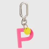 Llavero con dije en forma de letra A color rosado y pequeño dije circular amarillo con logo de la marca grabado. Incluye gancho metálico tipo mosquetón.