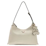 Cartera tipo hobo Guess modelo Kassie, color blanco, con cierre superior y correa ajustable. Presenta un dije colgante en forma de oso y detalle de logo triangular metálico en el frente.