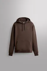 Sudadera de hombre Zara Athleticz de ajuste relajado (relaxed fit), color marrón, confeccionada en tejido técnico compacto con mezcla de algodón y elasticidad. Cuenta con cuello con capucha ajustable con cordones negros, manga larga, bolsillo frontal tipo canguro con un pequeño bolsillo termofijado con cierre, y acabados con rib en puños y cintura.