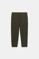 Pantalón de vestir color marrón oscuro, tiro alto, corte recto o ligeramente cropped, con pinzas frontales y bolsillos laterales.