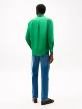 Camisa de popelina de algodón verde, con cuello abotonado, mangas largas con puños abotonados y logo de Tommy Hilfiger bordado en el pecho. Confeccionada con tecnología Flex para mayor comodidad.