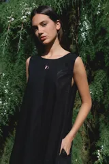 Vestido largo sin mangas de corte holgado, con cuello redondo y bolsillos laterales. Confeccionado en algodón, presenta un diseño minimalista y fluido.