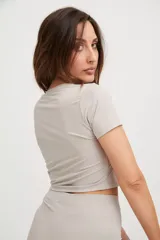 Remera corta de lycra color visón, de corte ajustado y mangas cortas.