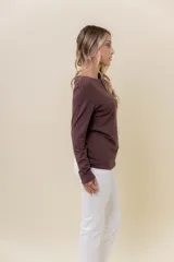 Remera de manga larga color chocolate, confeccionada en tela suave con elastano. Presenta un diseño de cuello bote y silueta entallada.