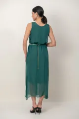 Vestido midi de gasa negro, con solera sin mangas, escote fruncido y detalle de aplique floral en el hombro.