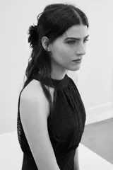 Vestido largo de encaje negro con escote halter, cuerpo ajustado y falda fluida con tajo frontal.