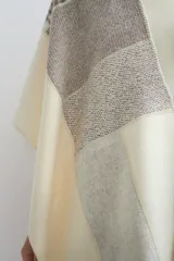Ruana tejida con diseño de bloques en tonos tierra y beige, con cuello en V y terminación de crochet artesanal.