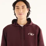 Campera deportiva New Balance de hombre, modelo Trackside, en color bordó con capucha ajustable, cierre frontal, bolsillos laterales y detalles de ribetes blancos en contraste.