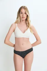 Bombacha tipo culotte less de color negro con estampado de lunares pequeños en color crema. Presenta un corte clásico con cobertura moderada.