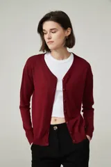 Cárdigan color beige con escote en V y cierre frontal con botones.