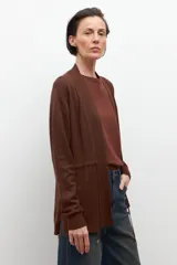 Ruana de tejido de punto color marrón chocolate, con cuello en V y diseño abierto, sin mangas.