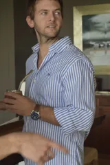 Camisa celeste y blanca a rayas verticales, de manga larga con puños abotonados y cuello clásico.