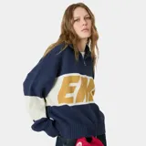 Buzo tejido de punto con cierre frontal metálico, cuello polo y diseño oversize. Presenta bloques de color en azul marino, blanco y amarillo con el logo de la marca tejido en técnica jacquard en el frente.