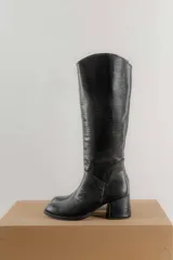 Bota de caña alta color marrón con textura símil reptil, taco cuadrado forrado en cuero y cierre lateral.