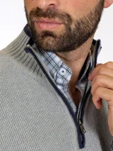 Sweater gris claro de tejido de punto con medio cierre frontal y cuello alto.