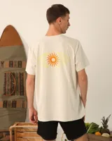 Remera unisex color crema con estampado de un sol anaranjado.