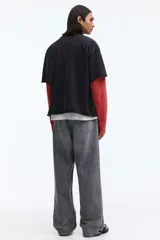 Remera boxy de algodón negro con efecto deslavado, corte oversized y mangas cortas. Presenta un estampado gráfico frontal con la inscripción "Golden Sunset" en estilo universitario.