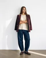 Blazer sastrero de lana bordó con trama espigada, silueta oversized, solapas clásicas, cierre de un botón y detalles en cuero natural.