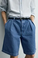 Bermuda de denim de algodón con corte relaxed fit, cintura con pliegues dobles en el delantero, bolsillos laterales y traseros de doble vivo, con efecto lavado y cierre frontal con cremallera y botón.
