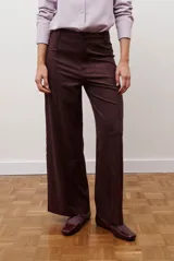 Pantalon de corte recto y tiro alto, confeccionado en un tejido de acabado suave y textura aterciopelada, con costuras verticales decorativas en el frente.