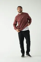 Buzo color ladrillo de felpa con logo estampado en el pecho y la espalda, corte regular, cuello redondo y puños en las mangas largas.