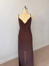 Vestido corto de microtul color marrón con diseño de doble capa, que incluye una base opaca y una capa exterior semitransparente. Presenta escote drapeado, tirantes finos y un ajuste ceñido al cuerpo con efecto fruncido lateral.