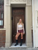 Body de encaje blanco con mangas largas y cuello redondo.