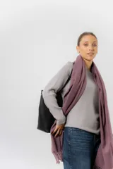 Bufanda tejida de textura suave y liviana, con terminación de flecos en los extremos.