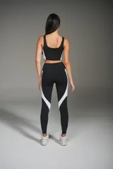 Calza deportiva larga negra con recortes laterales blancos.