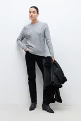 Sweater gris de tejido de punto con trenzas y perlas sintéticas.