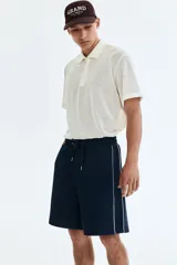 Short azul marino de punto con leve brillo, cintura elástica con cordón de ajuste y ribetes laterales en color blanco.