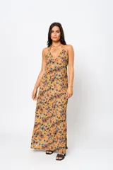 Vestido largo color ocre con estampado floral, escote en V y espalda descubierta.