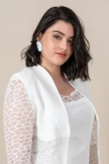 Vestido blanco de piqué con encaje en el escote, corte recto y largo a la rodilla. Incluye una túnica larga de la misma tela con tajos laterales y encaje al tono.