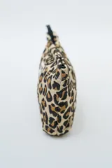 Neceser rectangular con estampado de personajes de anime en tonos vibrantes sobre fondo blanco. Cuenta con cierre superior negro.