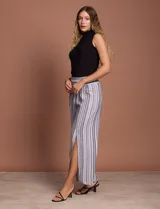 Pantalón de lino con rayas verticales grises y blancas, pretina ancha elastizada en punto smock, pierna ancha y ruedo con tajo.