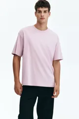 Remera de punto de algodón de peso medio en color lila, con cuello redondo ribeteado, hombros caídos y bajo recto. Diseño de corte relajado y silueta casual.