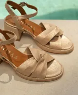 Sandalias de cuero color dorado, con plataforma y taco cuadrado. Presentan tiras cruzadas en el empeine y pulsera al tobillo con hebilla.