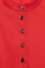 Camisa de algodón con cuello redondo y cierre frontal de botones a contraste. Presenta mangas abullonadas por debajo del codo y bajo asimétrico con aberturas laterales.