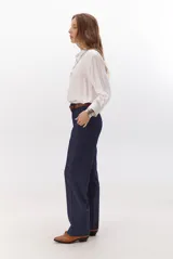 Pantalon de vestir azul marino, de corte recto y tiro alto, con cierre frontal y bolsillos laterales.