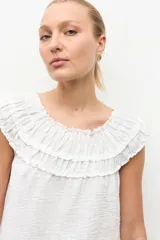 Blusa negra estilo bardot con escote de hombros descubiertos, detalles de volados fruncidos en el pecho y diseño sin mangas.