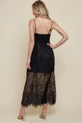 Vestido midi de tirantes finos con escote en V y cierre frontal de botones. La parte superior presenta un diseño estructurado con encaje, mientras que la falda incorpora una capa de encaje transparente con terminación en flecos tipo eyelash.