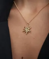 Collar plateado con dije en forma de estrella de puntas irregulares y centro circular.