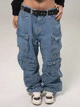 Pantalón tipo cargo de jean en color azul medio, con corte baggy fit y tiro bajo. Presenta múltiples bolsillos laterales con solapa y cierre de botón, además de un diseño holgado con frunces en la parte inferior de las piernas.