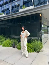 Pantalón blanco roto de corte recto con detalles de calados florales en las piernas.