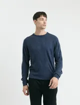 Sweater de tejido de punto con escote redondo y manga larga, con detalles de costuras en sisas y cuello. Presenta un diseño clásico y versátil.