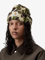 Gorro tipo beanie Carhartt de tejido polar con estampado de camuflaje. Presenta un parche rectangular con el logo de la marca en el frente.
