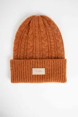Gorro tipo beanie de punto con diseño de ochos, color marrón, con vuelta en el borde y parche rectangular con el logo de la marca en el frente.