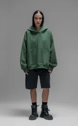 Hoodie oversize de corte crop, color verde, confeccionado en frisa gamuzada de algodón. Presenta capucha forrada y bolsillo canguro frontal.