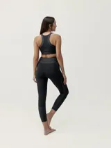 Top deportivo negro de sujeción media alta, confeccionado en tejido Shape_Tech con acabado satinado. Diseño con espalda deportiva.