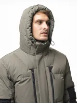 Campera puffer con capucha, de diseño bicolor en tonos gris topo y negro. Presenta cierre frontal con solapa de botones, bolsillos laterales y ajuste en los puños.